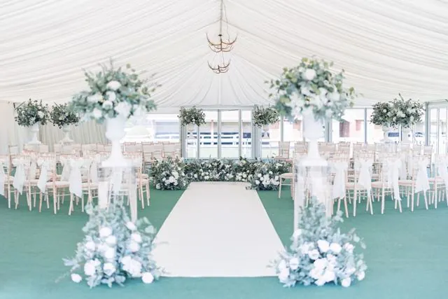 Marquee ceremony with white aisle and blue florals